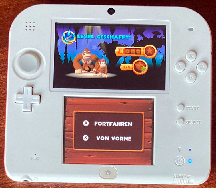 Nintendo 3DS mit dem Level Abschluss Bildschirm von Donkey Kong Country Returns: 3D. Es wurde ein KONG Buchstabe gefunden, sowie eins von fünf Puzzleteilen.